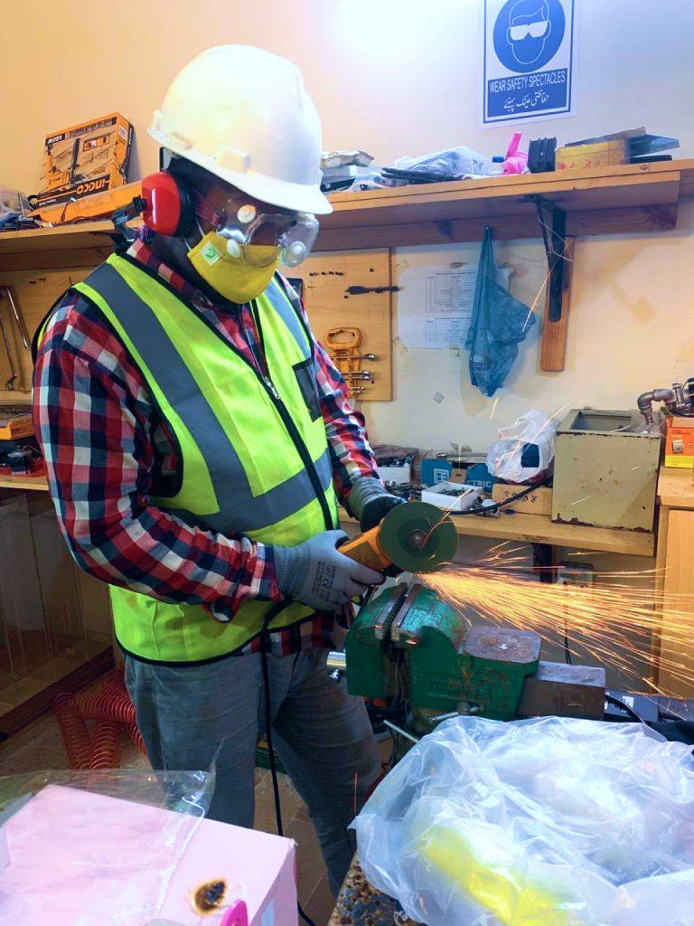 Fabricator grinding a machine frame